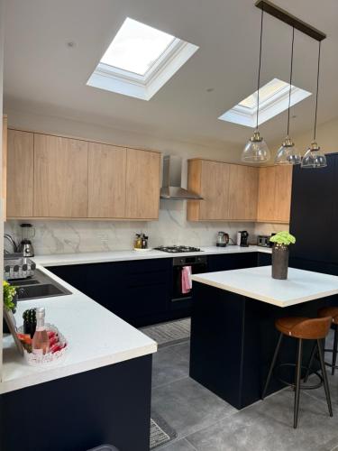 a kitchen with blue cabinets and a white counter top at Dreams House in Hendon