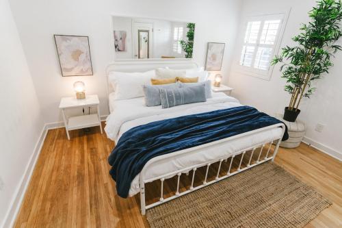 a white bedroom with a large bed with a blue blanket at LA Karaoke Fire Pit Ping-Pong Cowboy Pool in Glendale