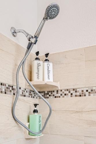 a shower with two bottles on a shelf in a bathroom at LA Karaoke Fire Pit Ping-Pong Cowboy Pool in Glendale