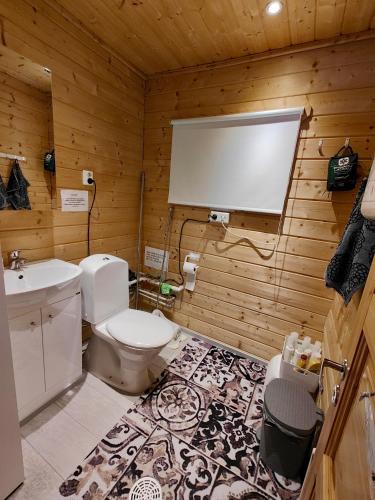 a bathroom with a toilet and a projection screen at Lomamökki seitsemisen kansallispuiston lähellä in Aurekoski