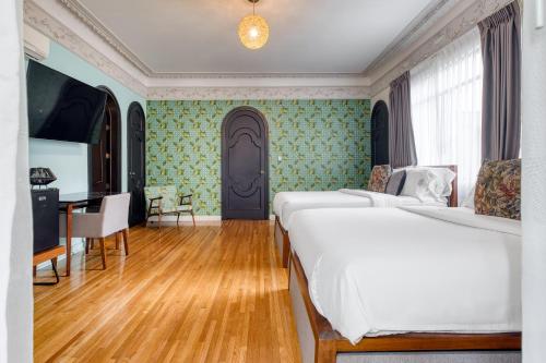 a bedroom with two beds and a desk and a door at Pug Seal Polanco Allan Poe in Mexico City