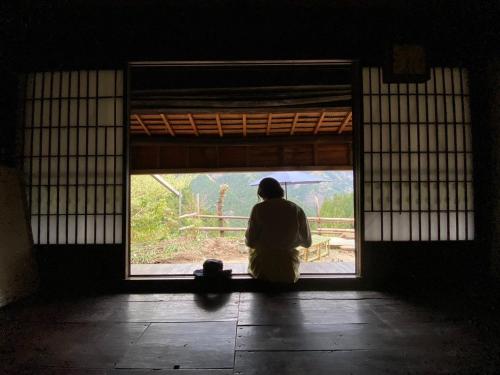 a person sitting in a room looking out of a window at Kominka Tsuruginoyado Yu - Vacation STAY 60931v in Kirikoshi