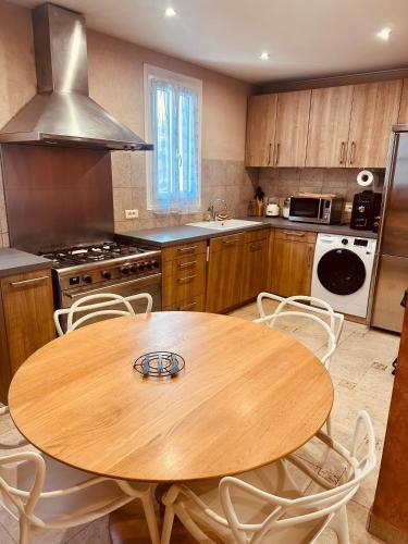 Il comprend une cuisine avec une table et des chaises en bois. dans l'établissement CASA BIANCA MAISON BLANCHE, à Saint-Florent