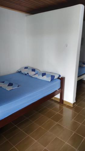 a bed with blue sheets and pillows in a room at Hotel Flórida in Salinópolis