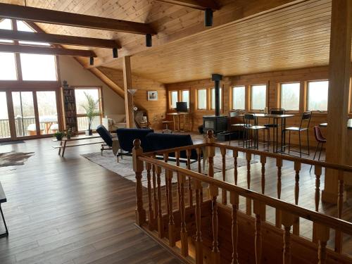 a large living room with wooden walls and windows at Charming barn loft - all amenities on 60 acre farm in the White Mountains of NH in Lancaster