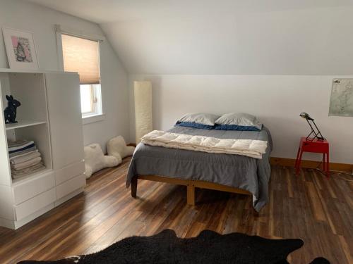 a bedroom with a bed and a wooden floor at Charming barn loft - all amenities on 60 acre farm in the White Mountains of NH in Lancaster