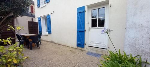 a door and a table and chairs in front of a building at Charmante maison de pêcheur in Carantec