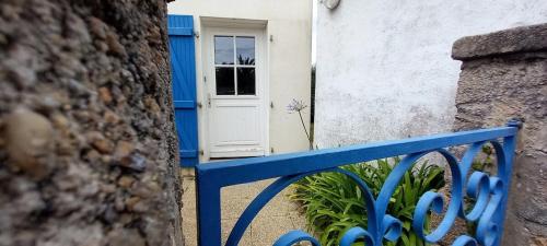 a blue bench in front of a building with a door at Charmante maison de pêcheur in Carantec