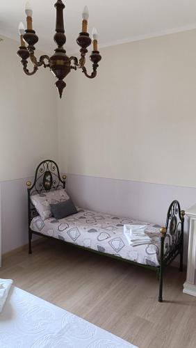 a bed in a room with a chandelier at La casetta rossa in Collicello