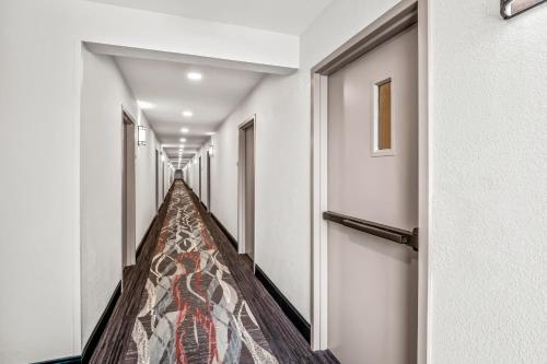 a hallway with a carpeted aisle in a building at HomeTowne Studios by Red Roof Southfield in Southfield