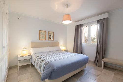 ポルト・ダ・ポリェンサにあるVilla Llenaire - La Goleta Villasの白いベッドルーム(ベッド1台、窓付)