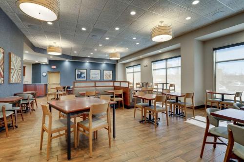 a dining room with tables and chairs and windows at Drury Plaza Hotel Mt Vernon in Mount Vernon