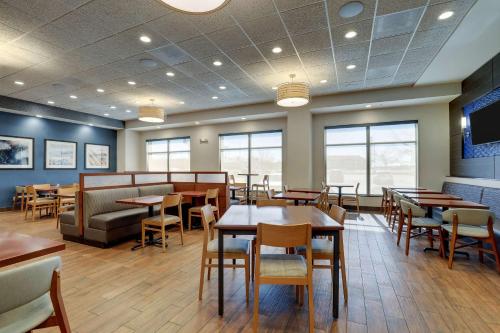 a dining room with tables and chairs and windows at Drury Plaza Hotel Mt Vernon in Mount Vernon
