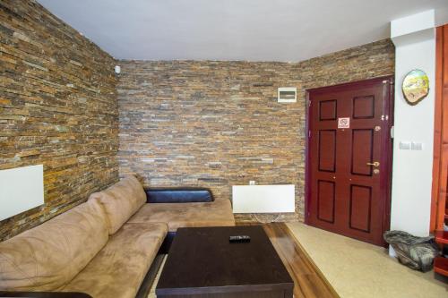 a living room with a couch and a brick wall at 2 bedroom, 2 showeroom Villa suitable for a family skication and remote working in Pamporovo