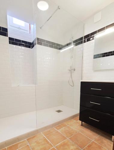 une salle de bain avec une douche avec une porte vitrée dans l'établissement Levant des Templiers, 2 chambres, vue mer, centre historique, à Hyères