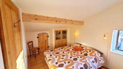 une chambre avec un lit et une chaise dedans dans l'établissement Levant des Templiers, 2 chambres, vue mer, centre historique, à Hyères