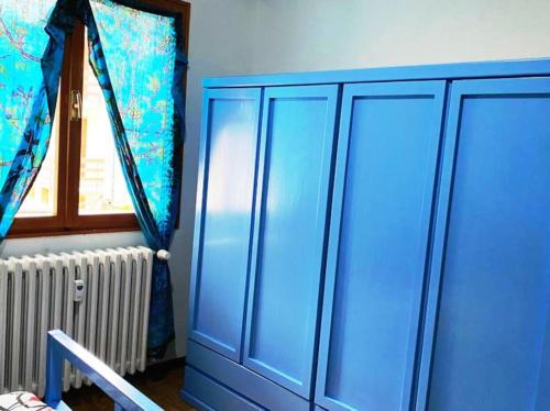 a blue cabinet in a room with a window at Appartamento immerso nella tranquillità in Bobbio