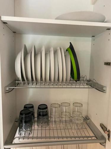 a shelf with plates and glasses in a refrigerator at Appartamento immerso nella tranquillità in Bobbio