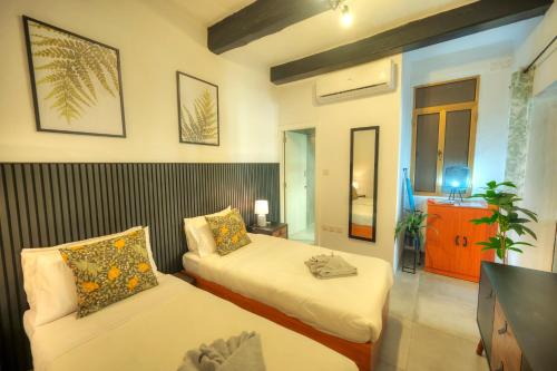 a hotel room with two beds and a tv at Cozy flat. Swim beach 2 minutes walk. The Old Valletta MCRI1-1 in Valletta