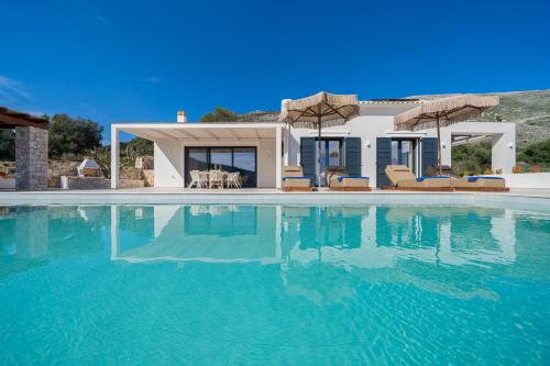 a swimming pool in front of a house at Ionian Infinity Villa in Ayia Evfimia
