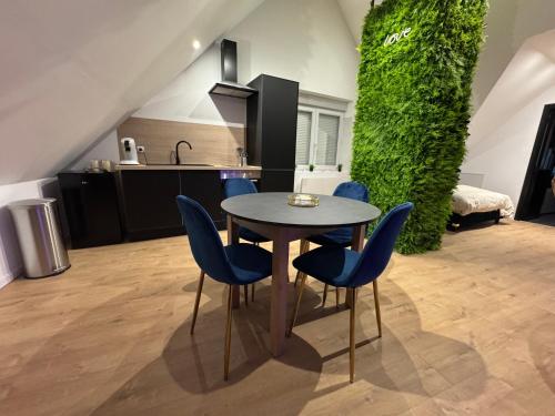 - une cuisine avec une table et des chaises bleues dans la chambre dans l'établissement Love appartement proche plage, à Wimille