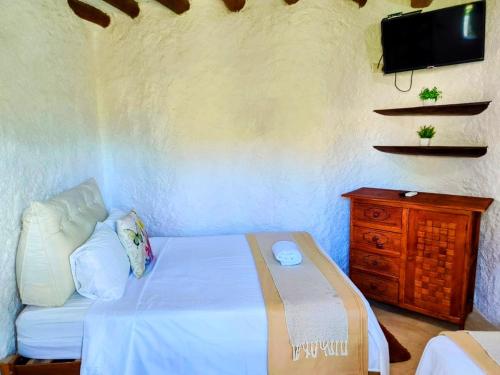 a bedroom with a bed and a tv on a wall at Arte Sano Hotel Only Adults - Near Beach in Holbox Island
