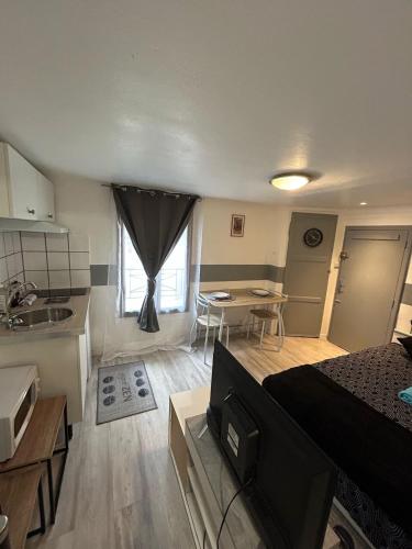 une chambre avec un lit et une cuisine avec une table dans l'établissement Naranjas - Fibre Wi fi - Centre ville, à Troyes