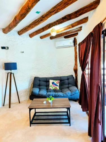a living room with a blue couch and a table at Arte Sano Hotel Only Adults - Near Beach in Holbox Island