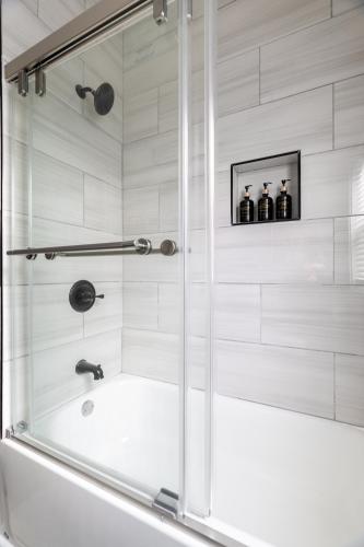 a bathroom with a shower with a bath tub at Luxury Short and Midterm Hyde Park Getaway in Cincinnati
