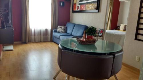 a living room with a table and a couch at Acogedor departamento, Zona Norte in San José el Alto