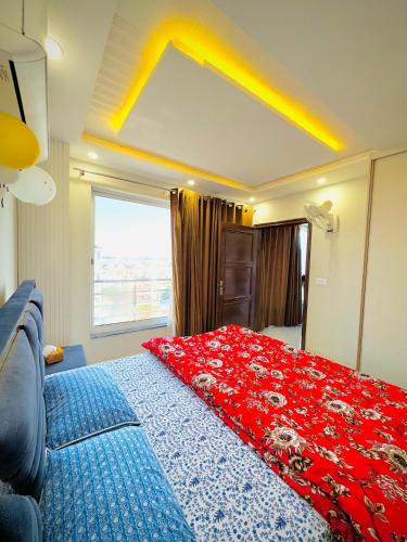 a bedroom with a large bed with a red blanket at Shazi Heights in Lahore