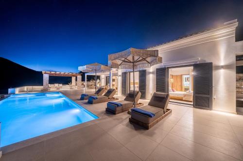 a villa with a swimming pool and lounge chairs at Ionian Infinity Villa in Ayia Evfimia