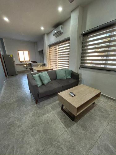 a living room with a couch and a coffee table at Tritón Apartment, ground floor and pool in Barra de Navidad