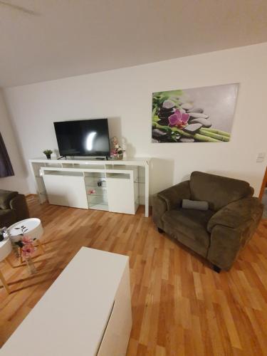 a living room with a couch and a flat screen tv at Ferienwohnung zur Sonne in Mahitzschen