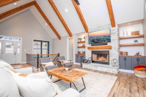 a living room with a fireplace and a table at Luxury Lakeside Living at Knot Working on Norris Lake in La Follette