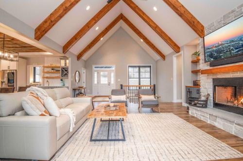 a living room with a white couch and a fireplace at Luxury Lakeside Living at Knot Working on Norris Lake in La Follette
