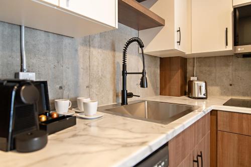 a kitchen with a sink and a counter top at Le Boréal Abitibi Hôtel in Val-dʼOr