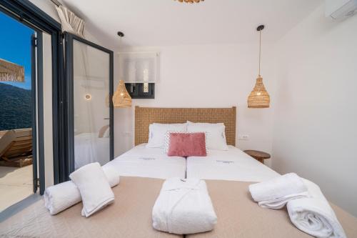 a bedroom with a large bed with towels on it at Ionian Infinity Villa in Ayia Evfimia