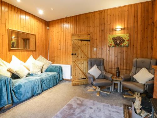 a living room with a couch and two chairs at Rose Cottage in Stranraer