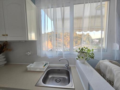 a kitchen with a sink and a window at Esperides apartment in Agia Triada