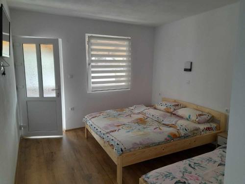 a bedroom with two beds and a window at Klarissz Vendèghàz in Praid