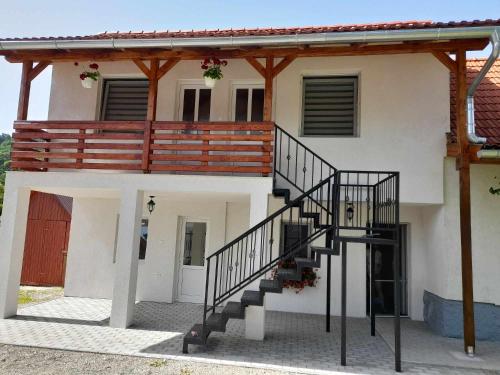 a house with a staircase in front of it at Klarissz Vendèghàz in Praid