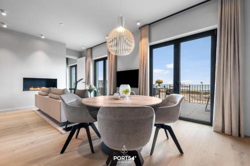 a dining room with a table and chairs and a couch at Waterfront Suite List auf Sylt in List