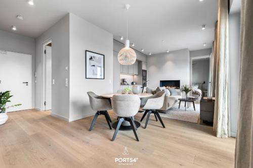 a dining room and living room with a table and chairs at Waterfront Suite List auf Sylt in List