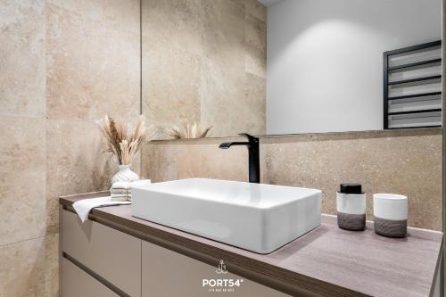 a bathroom with a white sink on a counter at Waterfront Suite List auf Sylt in List