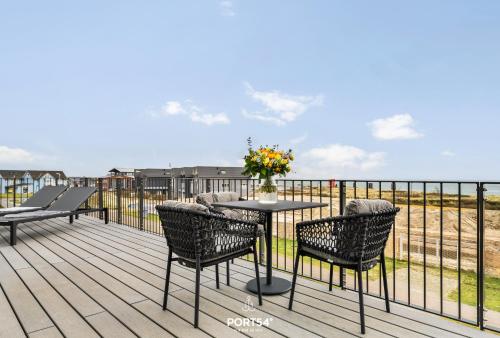 a patio with a table and chairs on a deck at Waterfront Suite List auf Sylt in List