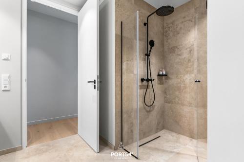 a shower with a glass door in a bathroom at Penthouse Suite List auf Sylt in List