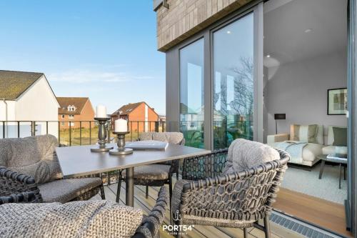 a patio with a table and chairs on a balcony at Nordic Suite List auf Sylt in List