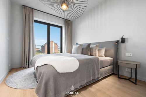 a bedroom with a large bed and a large window at Nordic Suite List auf Sylt in List