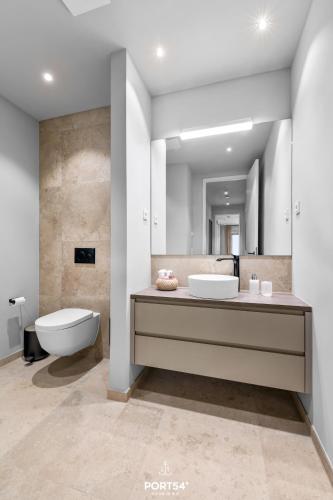 a bathroom with a sink and a toilet and a mirror at Sunrise Suite List auf Sylt in List